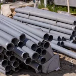 Stacks of gray PVC pipes outdoors