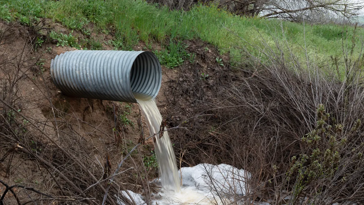 Corrugated drain pipe discharging water outdoors