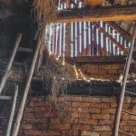Dark crawl space with ladders and debris